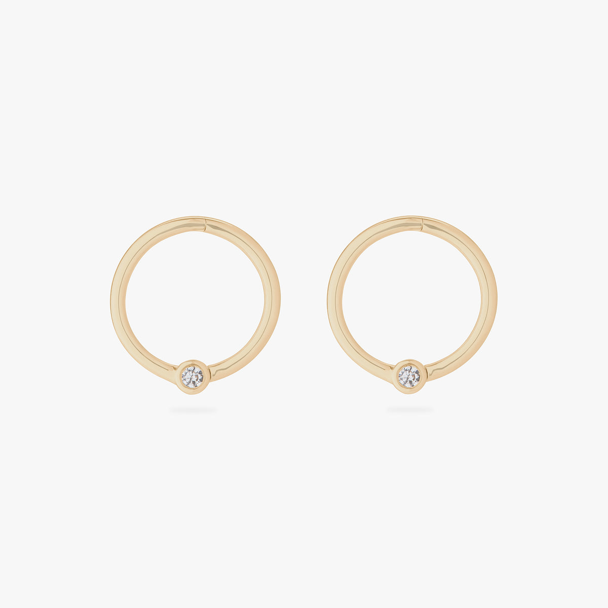 this image shows a pair of 10mm 14k yellow gold clickers with a cz bezel 