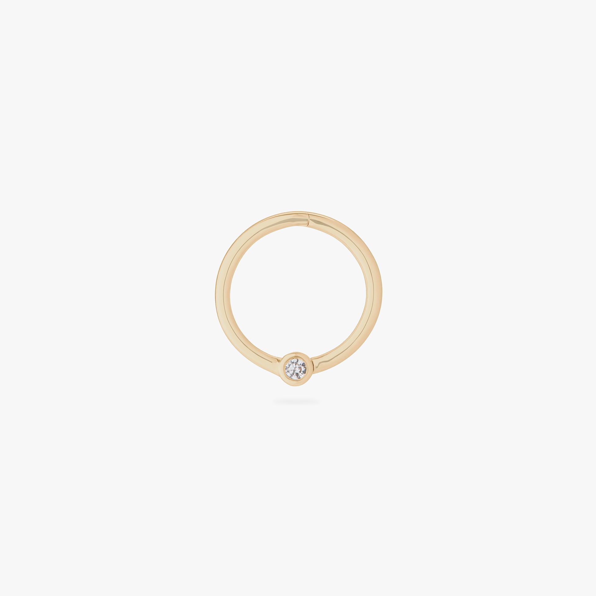 This is an image of a 14K gold clicker that is 10mm wide with a bezel set crystal CZ against a white background. - Main view