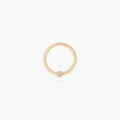 This is an image of a 14K gold clicker that has a 10mm diameter and a bezel set crystal CZ against a white background. 