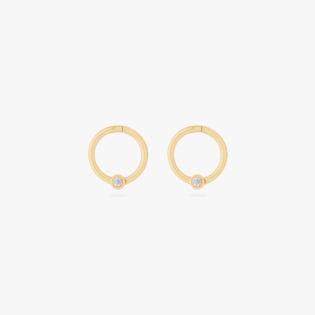 this image shows a pair of 14k gold plated titanium front face clickers with a clear cz 