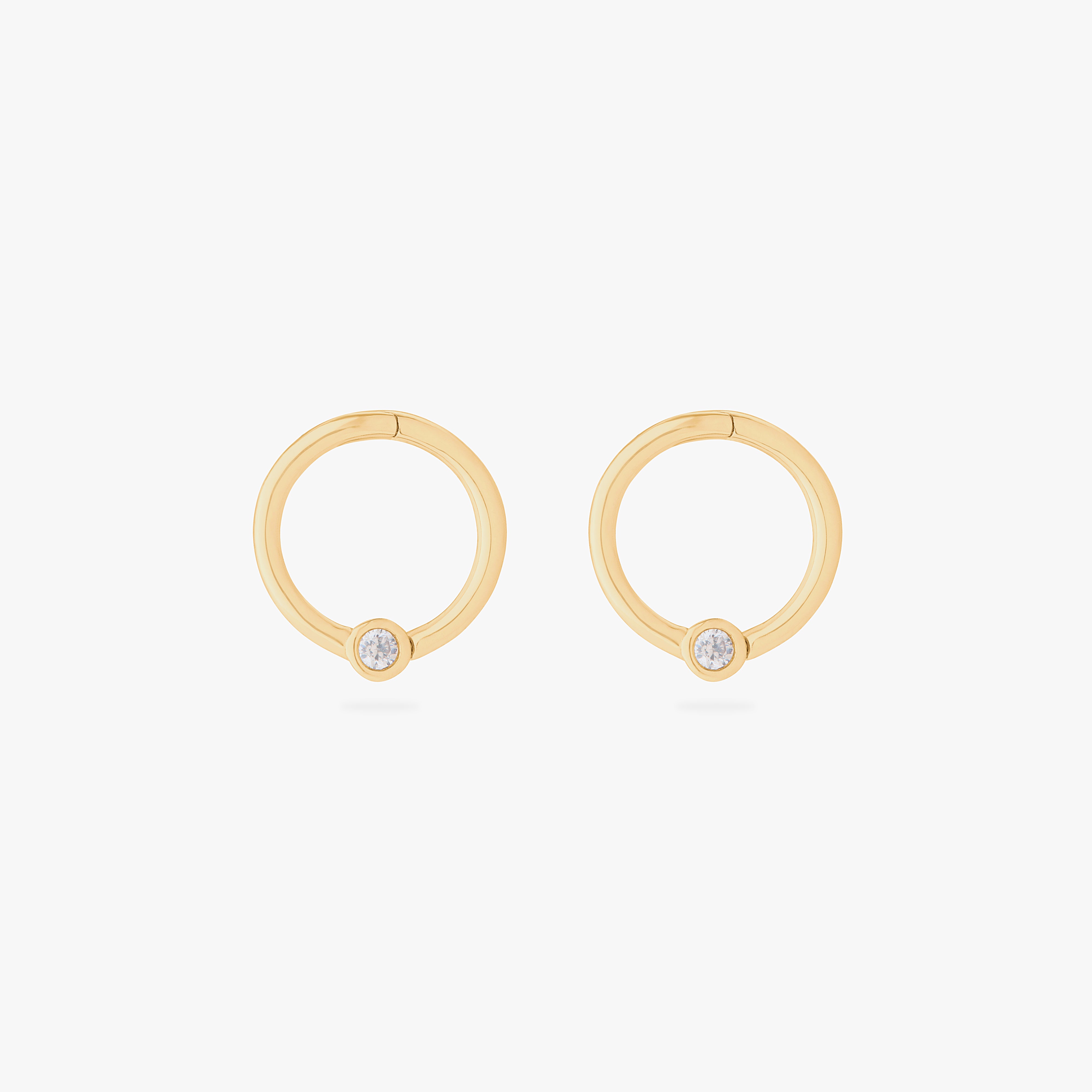 this image shows a pair of 14k gold plated titanium front face clickers with a clear cz - Pair view