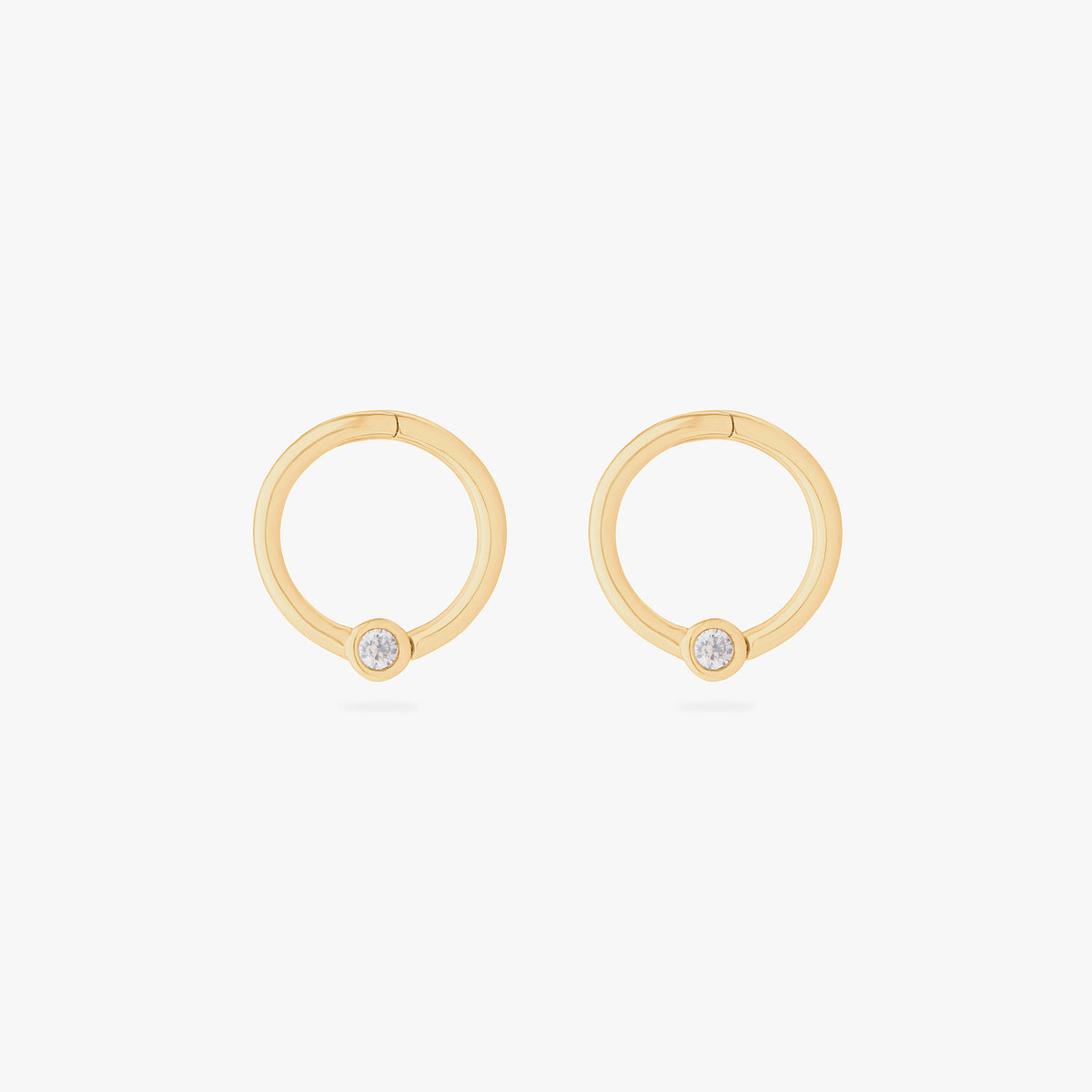this image shows a pair of 14k gold plated titanium front face clickers with a clear cz 
