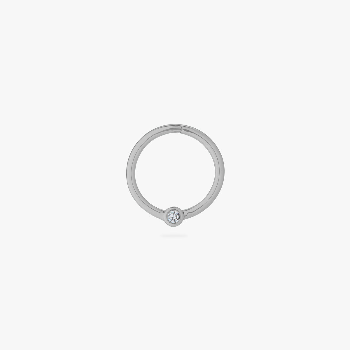This is an image of a silver-toned titanium clicker that is 10mm wide with a bezel set crystal CZ against a white background.
