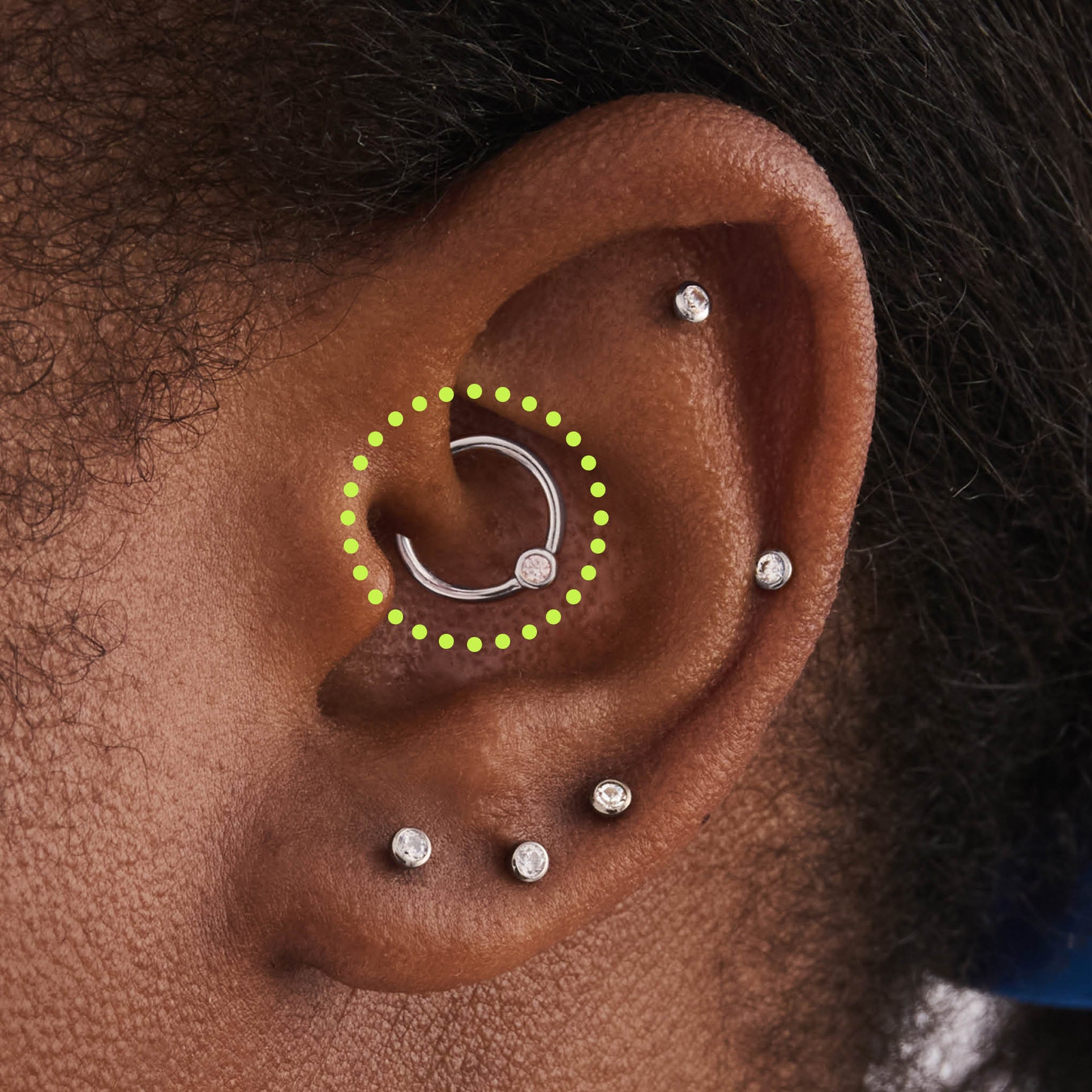 This is an image of a silver-toned titanium clicker that is 8mm wide with a bezel set crystal CZ circled on an ear. - Alternative view 1