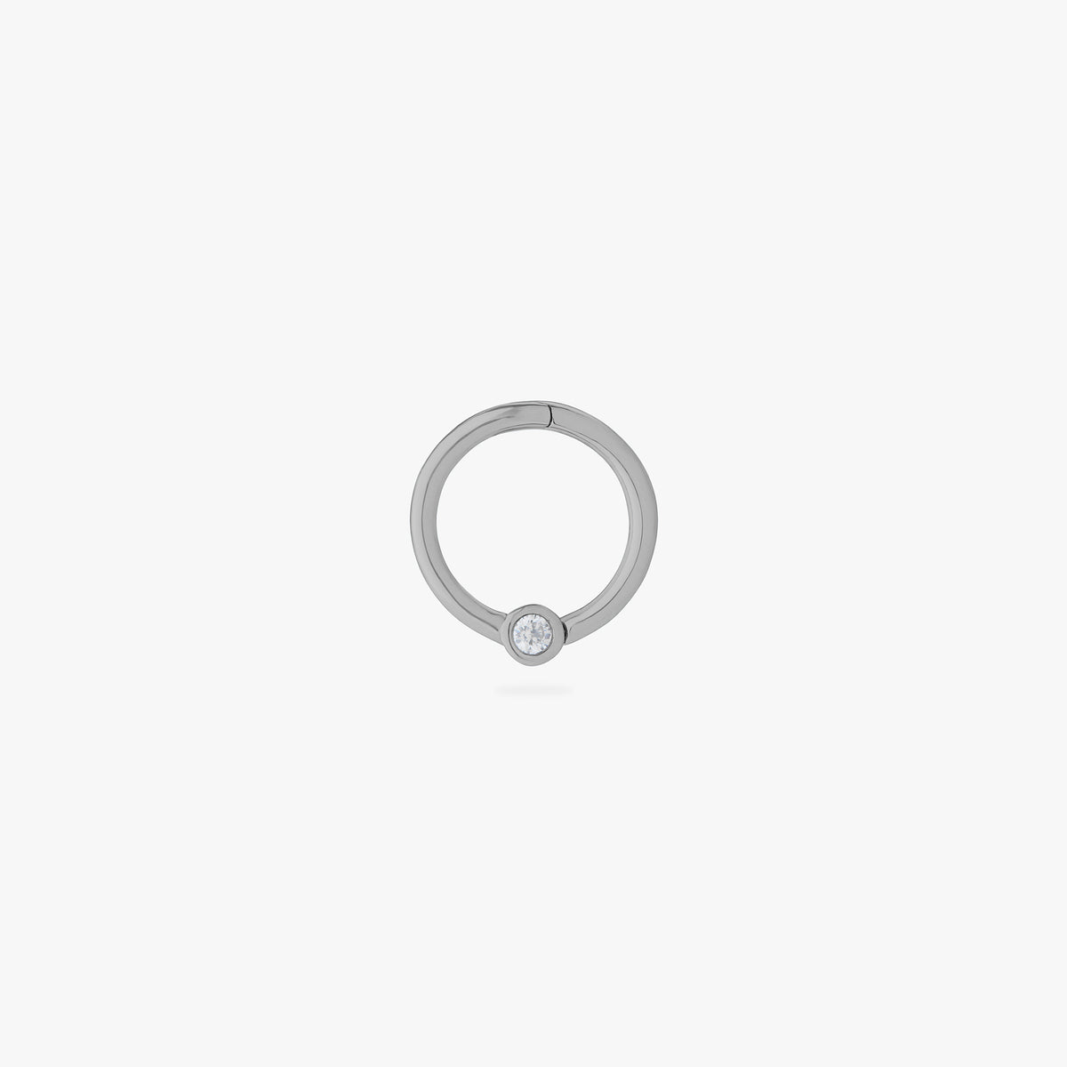 This is an image of a silver-toned titanium clicker that is 8mm wide with a bezel set crystal CZ against a white background. - Main view