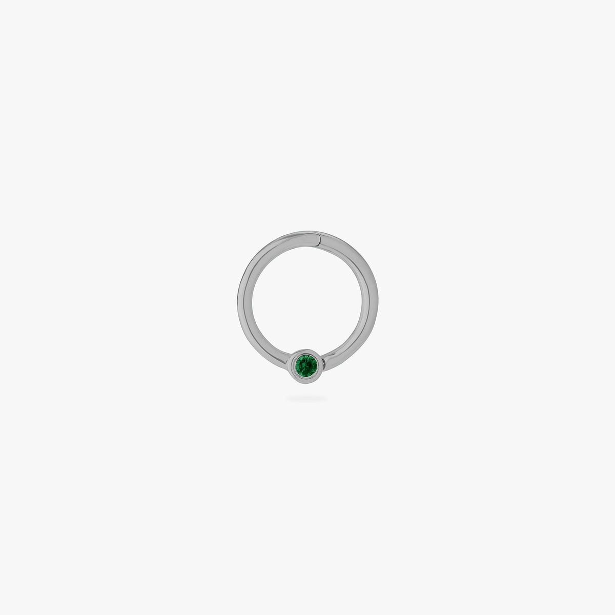 This is an image of a silver-toned titanium clicker that is 8mm wide with a bezel set green CZ against a white background.