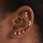 This is an image of a 14K gold clicker that is 8mm wide circled on an ear.