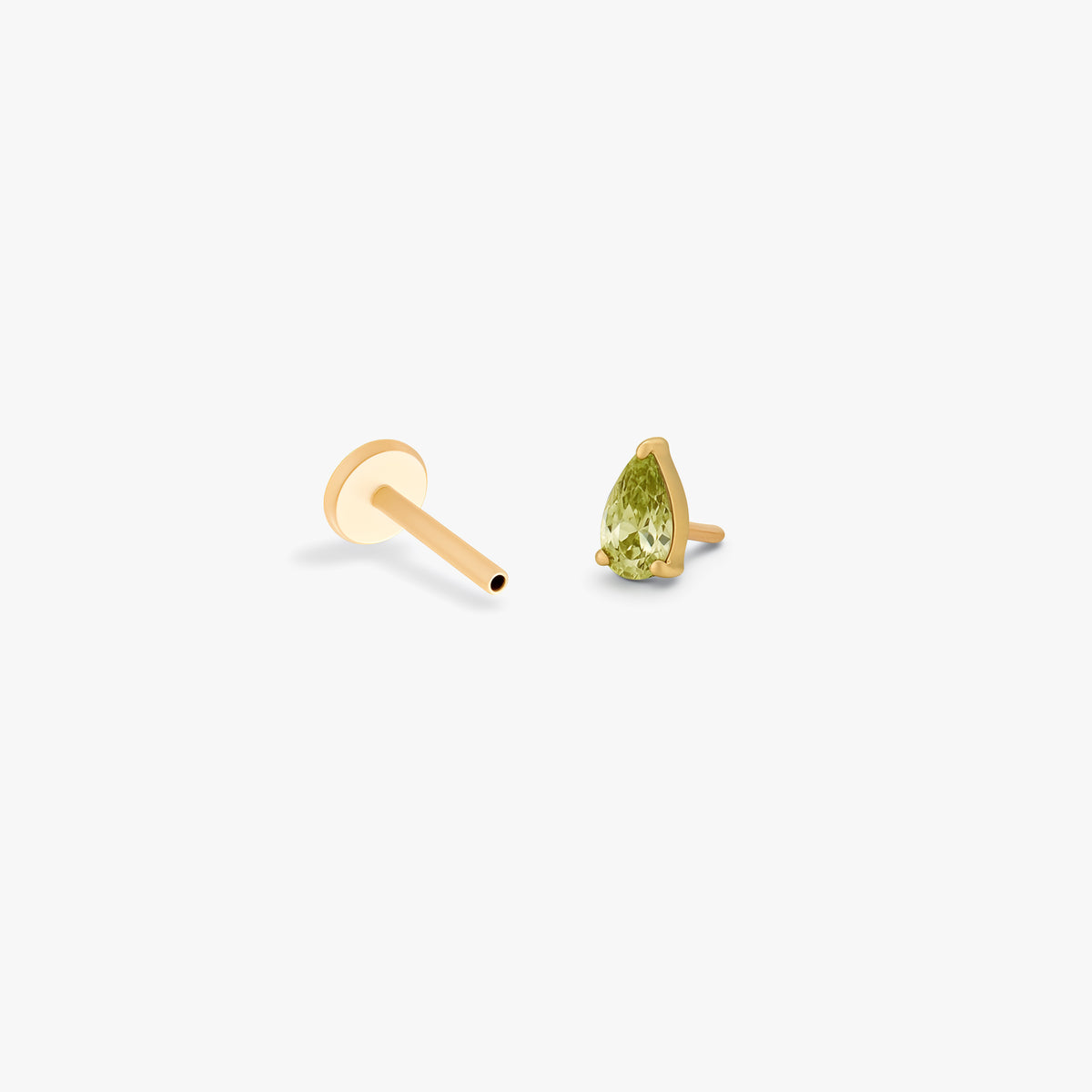 this image shows a side angle view of a Golden Titanium pear flatback with a green cz stone separated from labret.