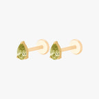 this image shows a side angle view of a pair of the Golden Titanium pear flatback with a green cz stone. 
