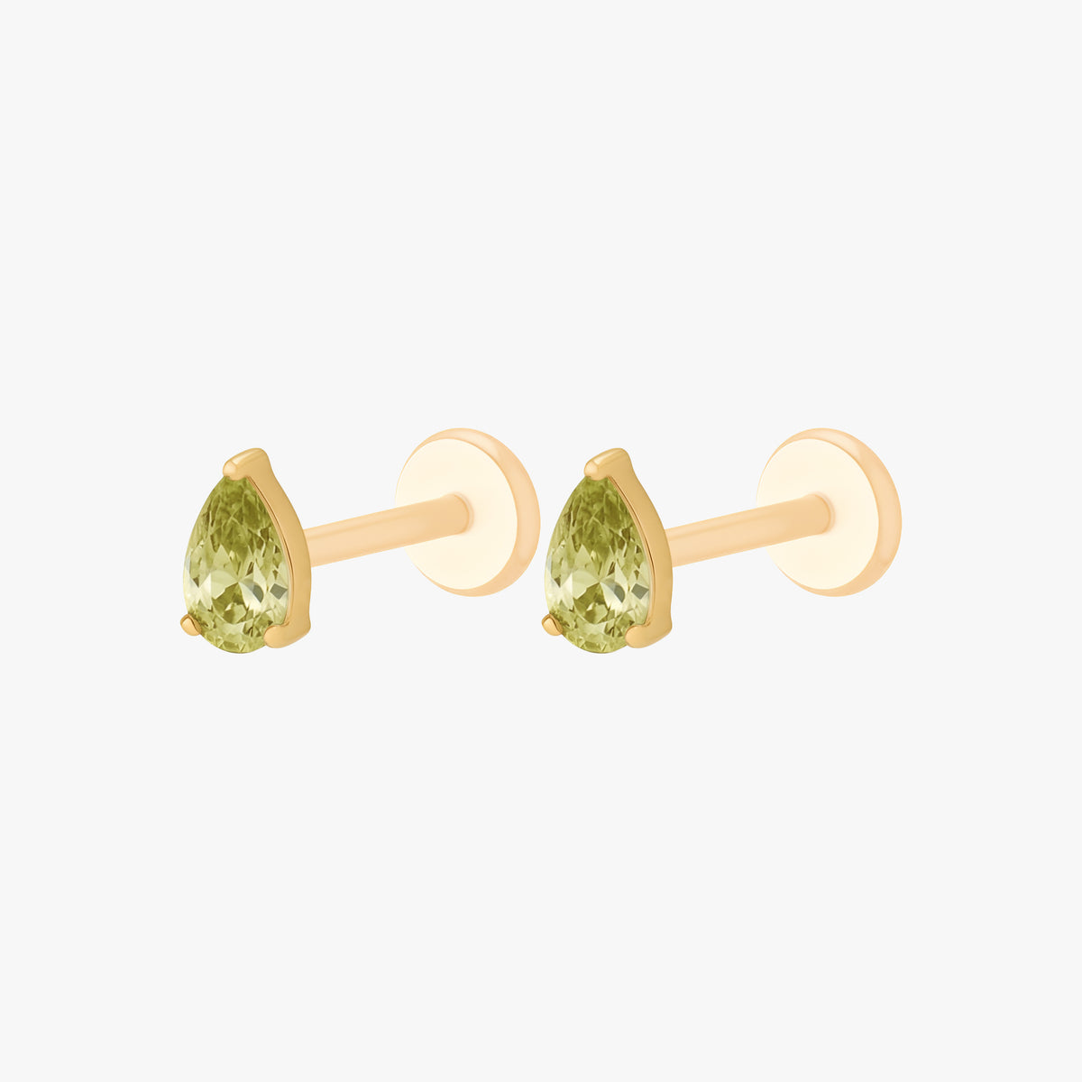 this image shows a side angle view of a pair of the Golden Titanium pear flatback with a green cz stone. 