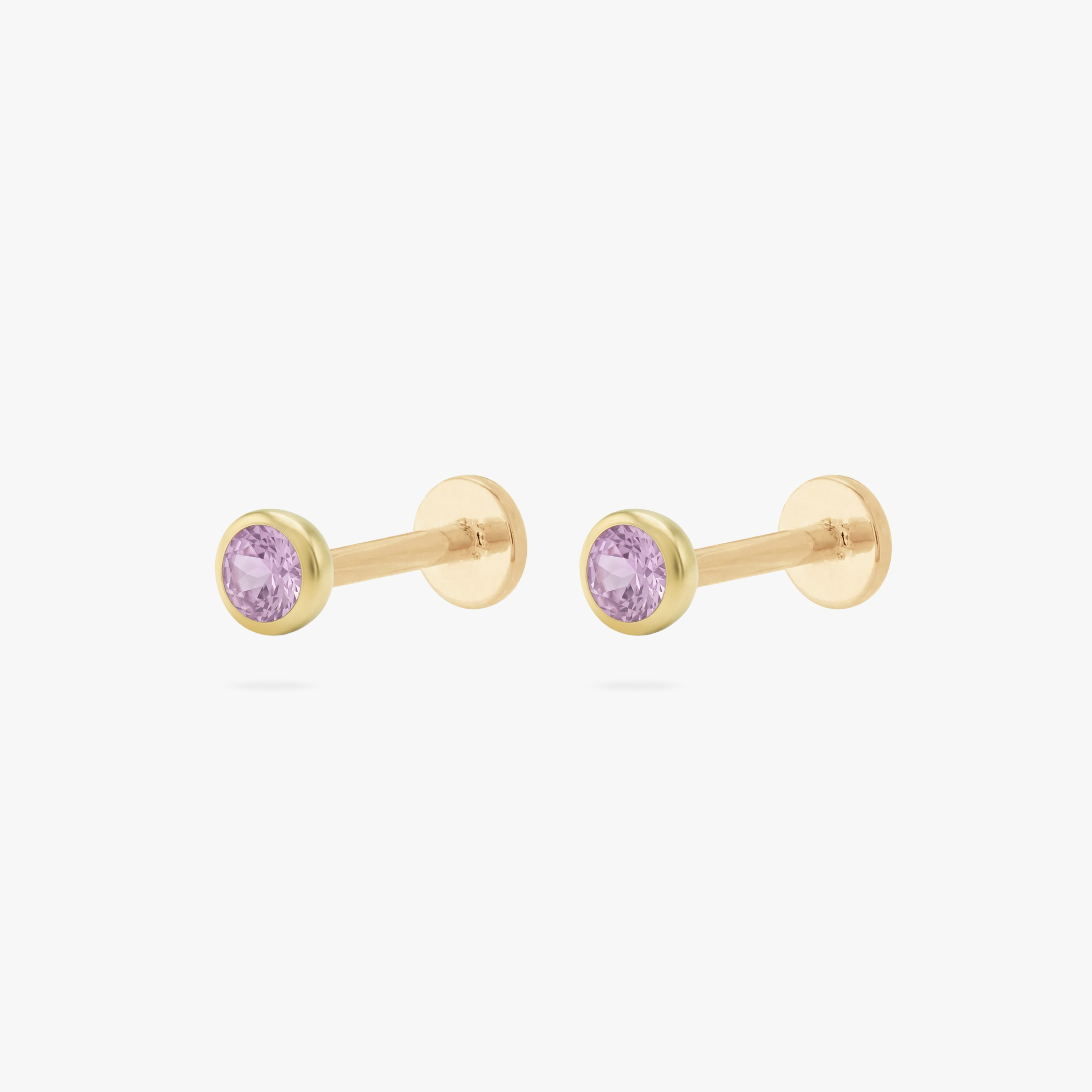 This is an image of a pair of gold toned flatback studs with 3mm, bezel set pink CZ stones. - Pair view