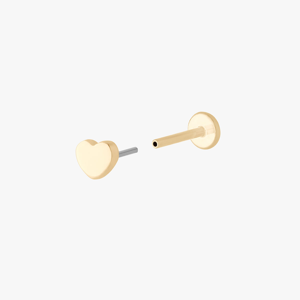 This is an image of a 14k gold flatback stud in the shape of a heart separated from labret. 