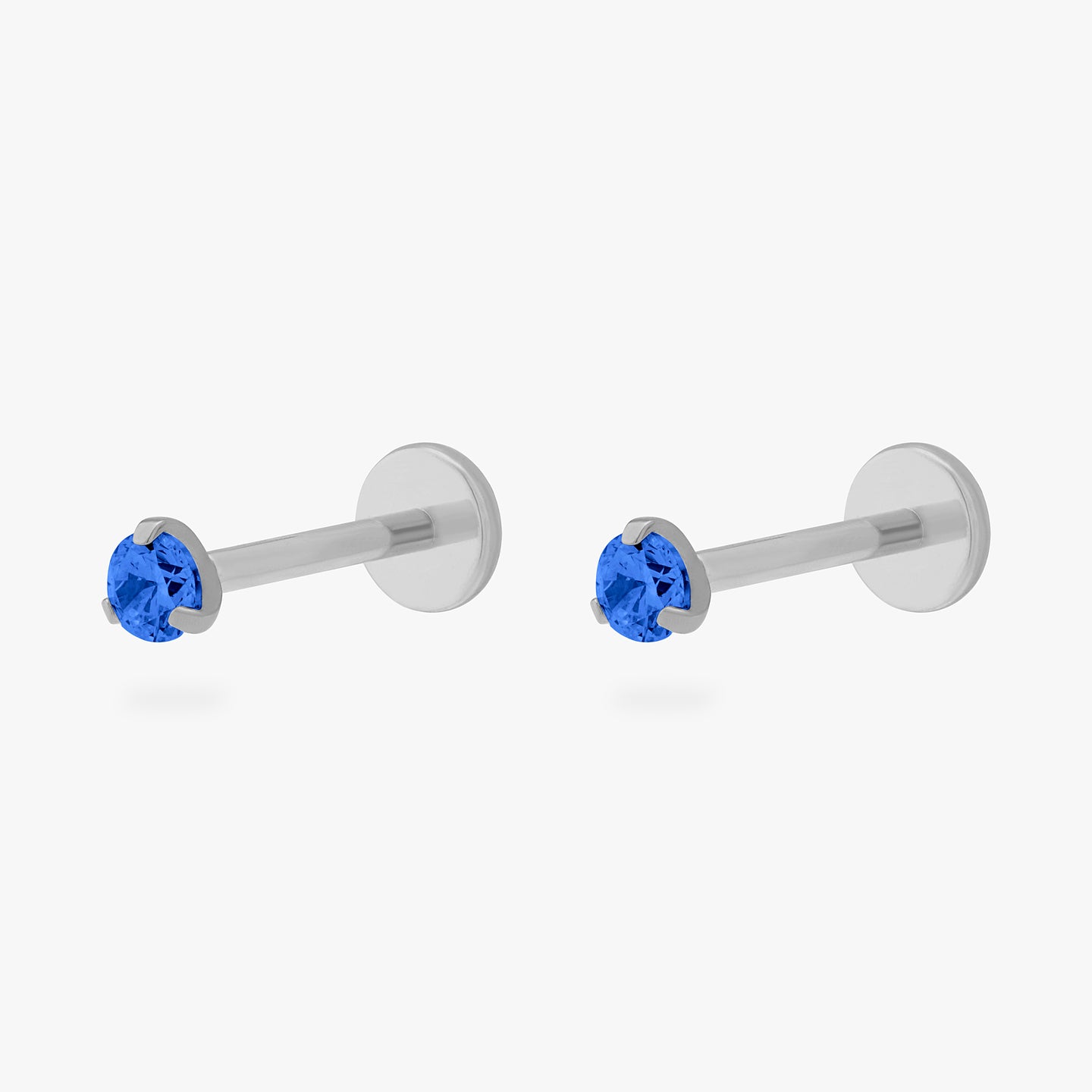 This is a pair of silver toned titanium flatback studs with mini sapphire cz stones. [pair] color:null|sapphire