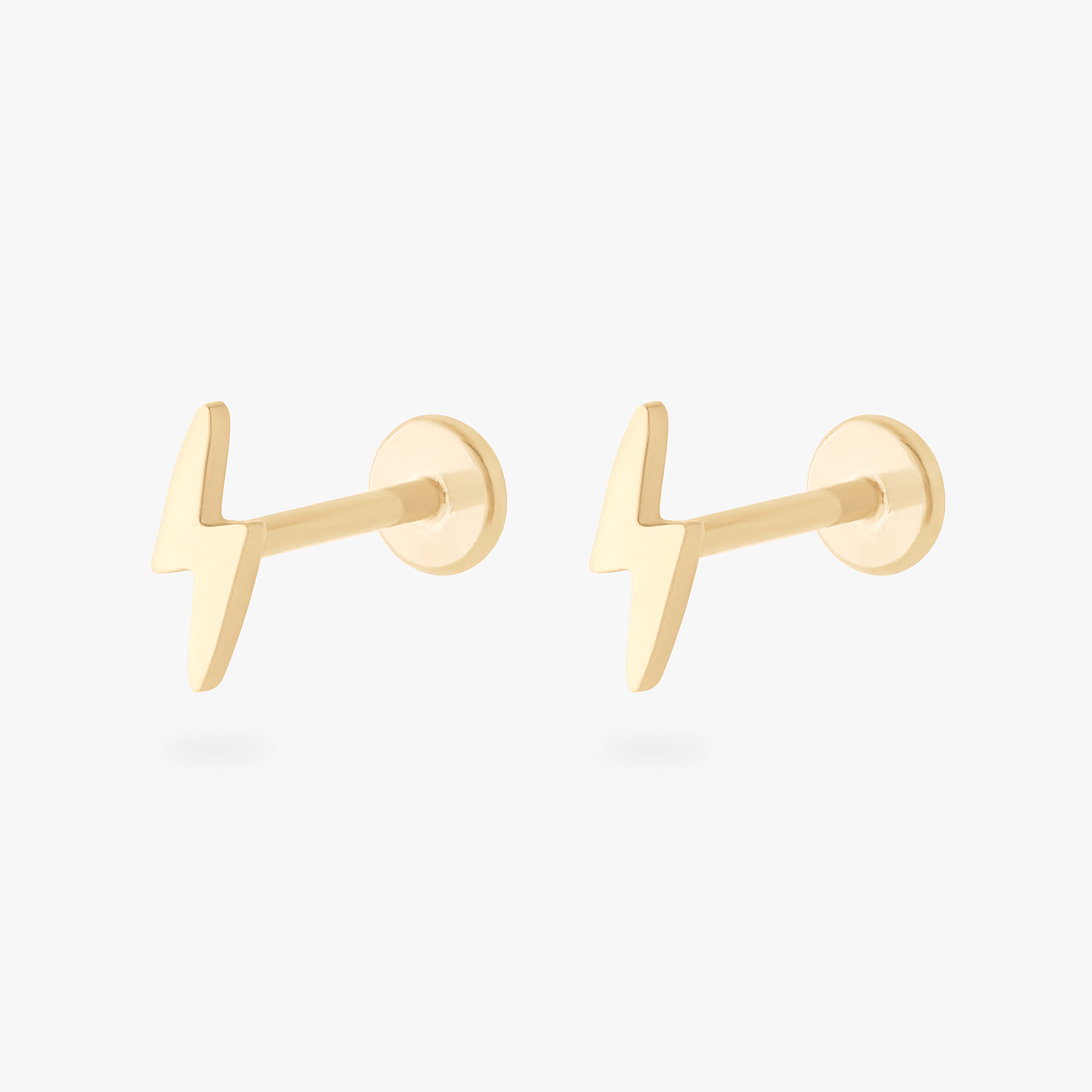 This is an image of a pair of 14k gold flatback studs that are shaped like lightning bolts. - Pair view
