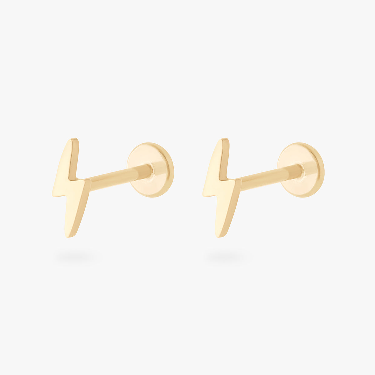 This is an image of a pair of 14k gold flatback studs that are shaped like lightning bolts.