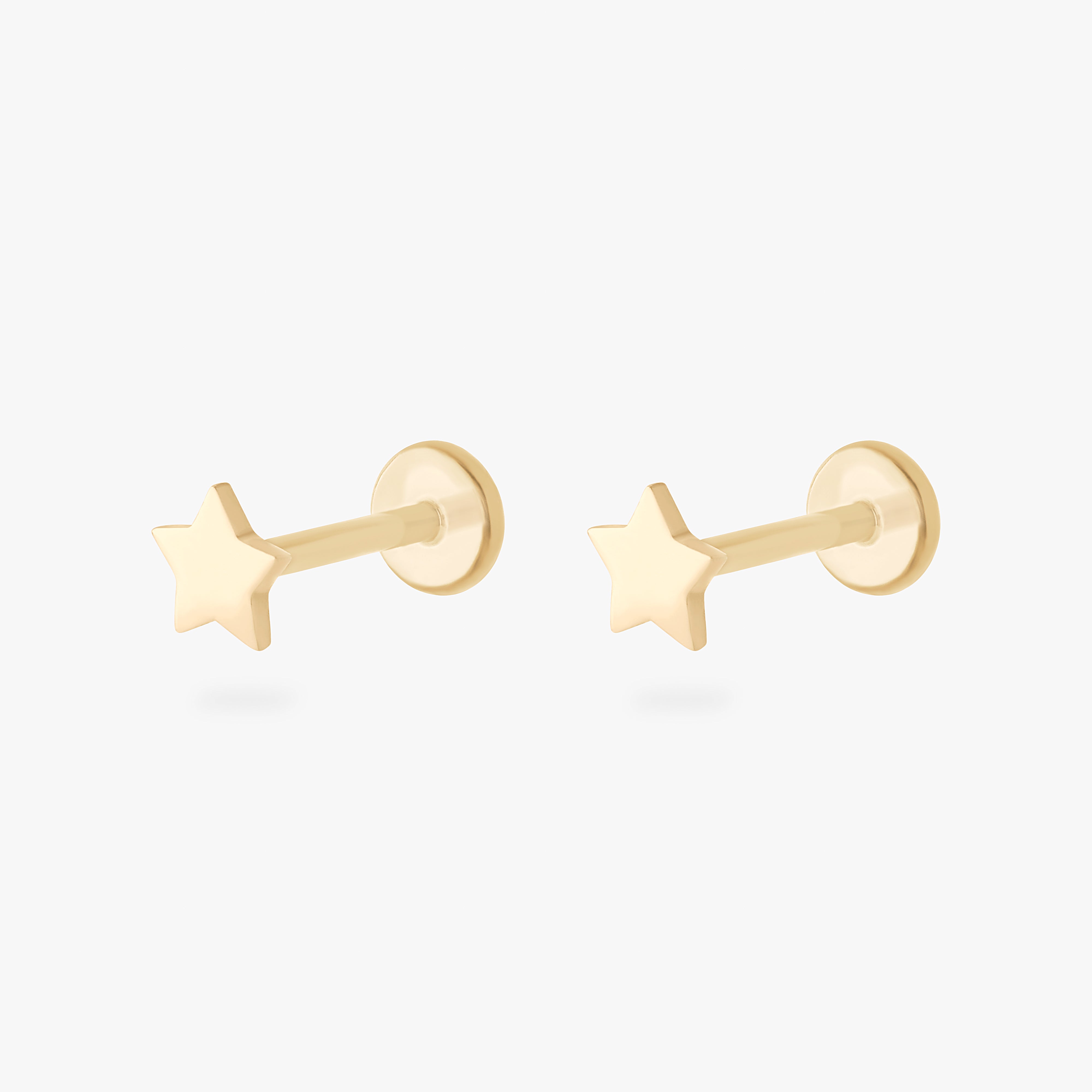 This is an image of a pair of 14K gold flatback studs that are in the shape of stars.