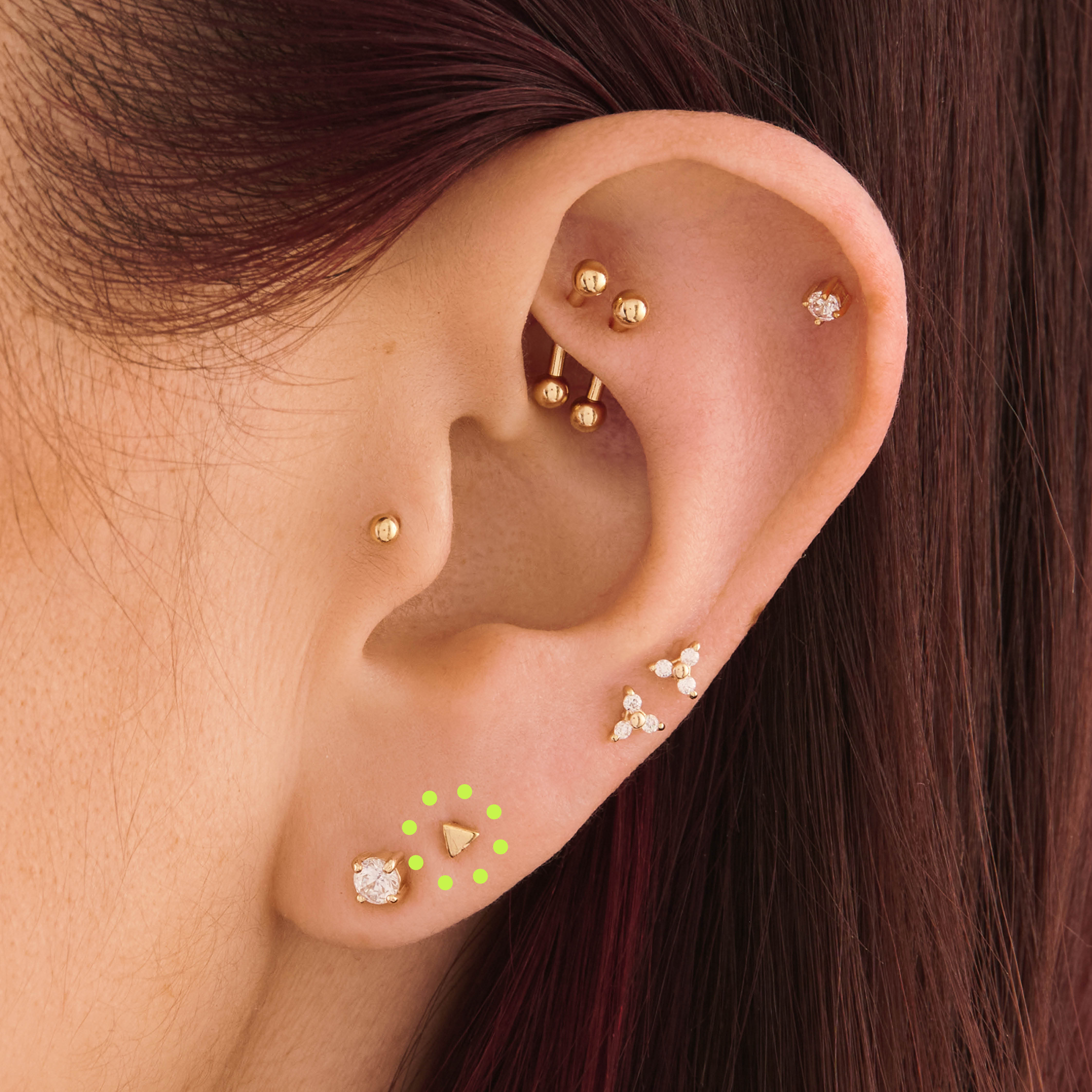 This is an image of a 14k gold flatback stud that is a solid gold triangle shape on ear. [hover] color:null|14k gold