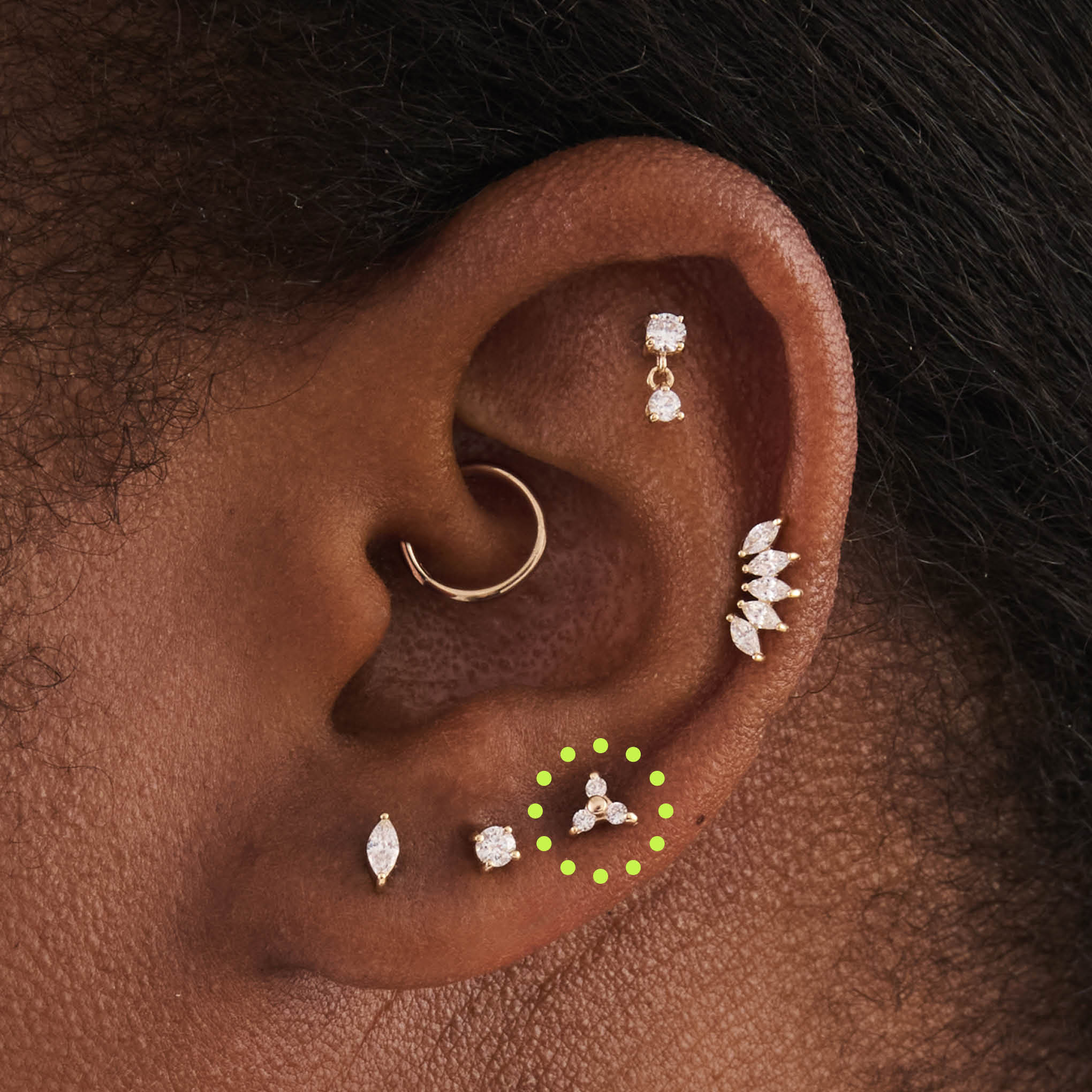 This is an image of a gold flatback stud that has 3 cz stones in the shape of a triangle on ear. - Alternative view 2
