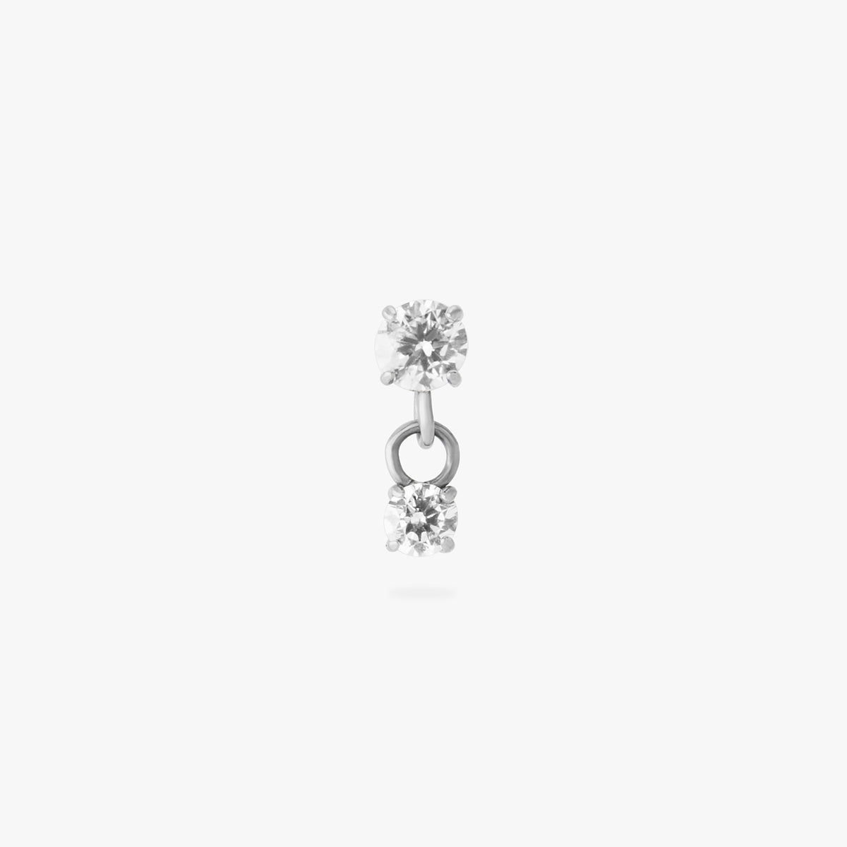 This image is a silver toned titanium flatback stud that features a larger crystal CZ stone with a smaller crystal CZ stone dangling from it against a white background. - Main view