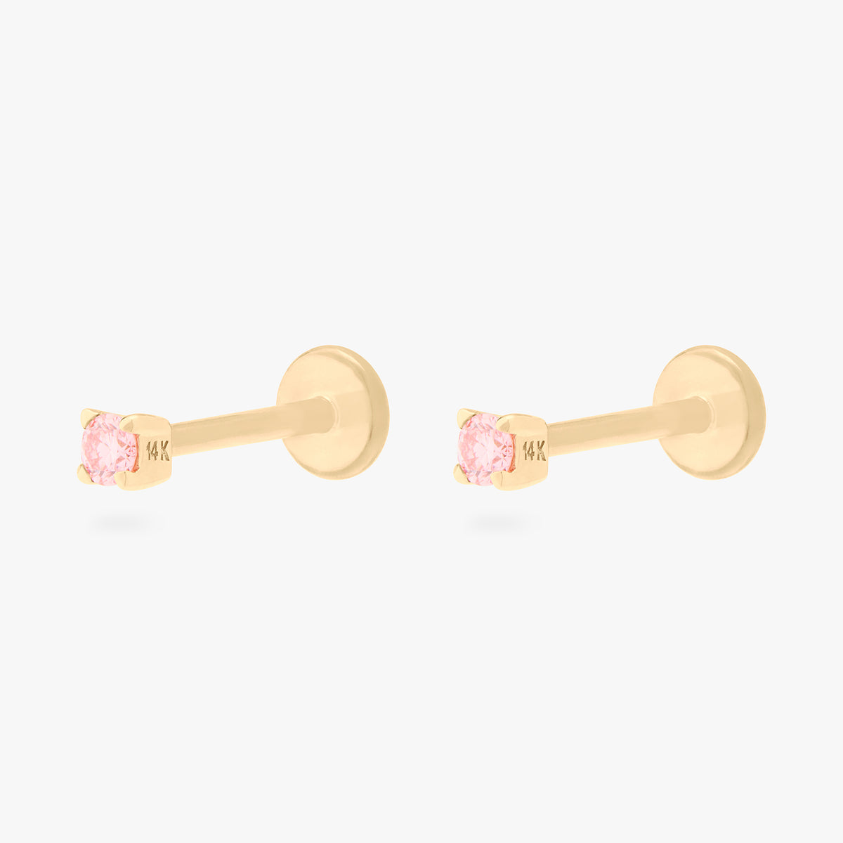 This image shows a pair of flatback studs made of 14K gold with round pink diamond stones with their gold-toned labret backs on. 