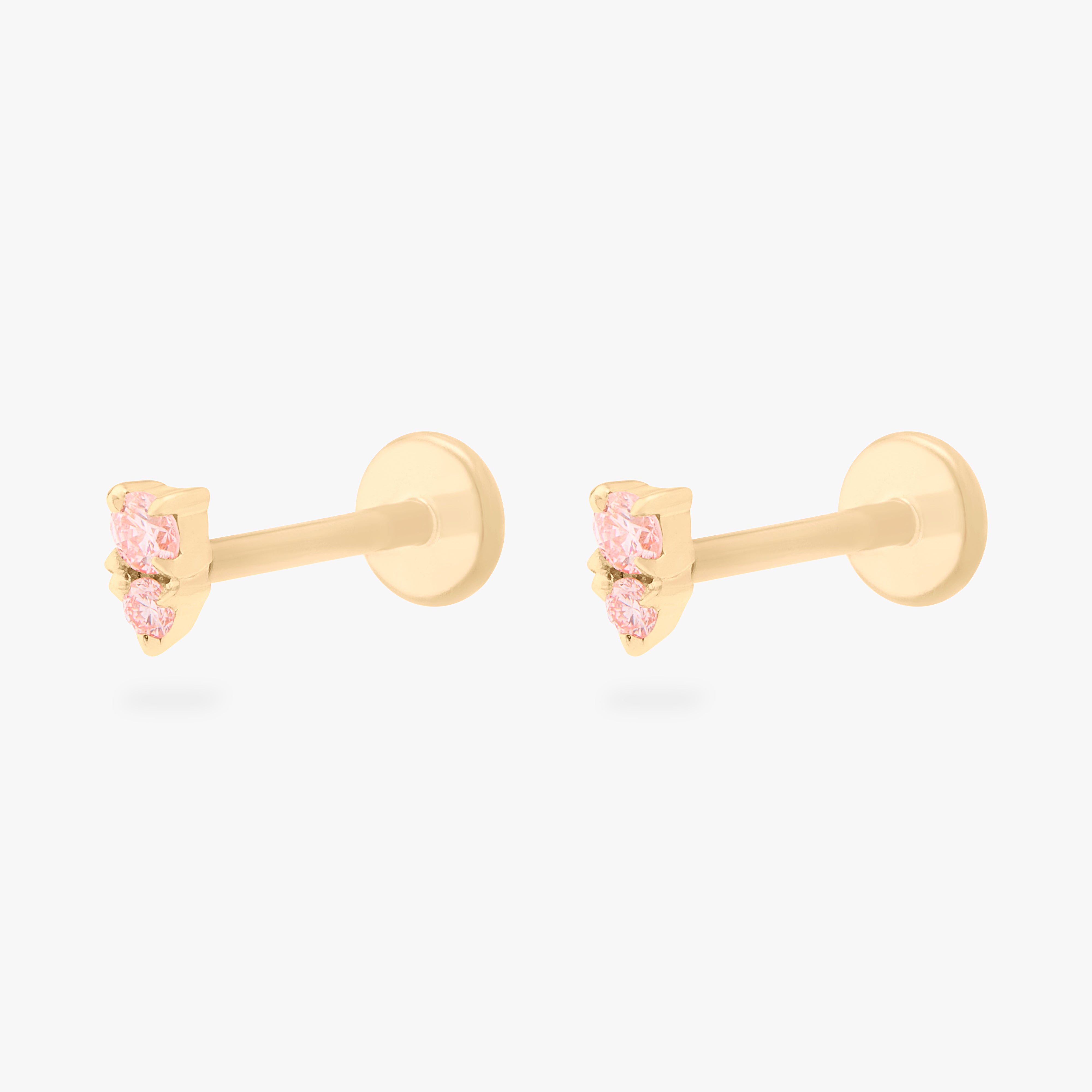 This image shows a pair of flatback studs made of 14K gold with round pink diamond stones that are stacked over small triangular pink diamond stones with their gold-toned labret backs on - Pair view