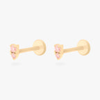 This image shows a pair of flatback studs made of 14K gold with round pink diamond stones that are stacked over small triangular pink diamond stones with their gold-toned labret backs on