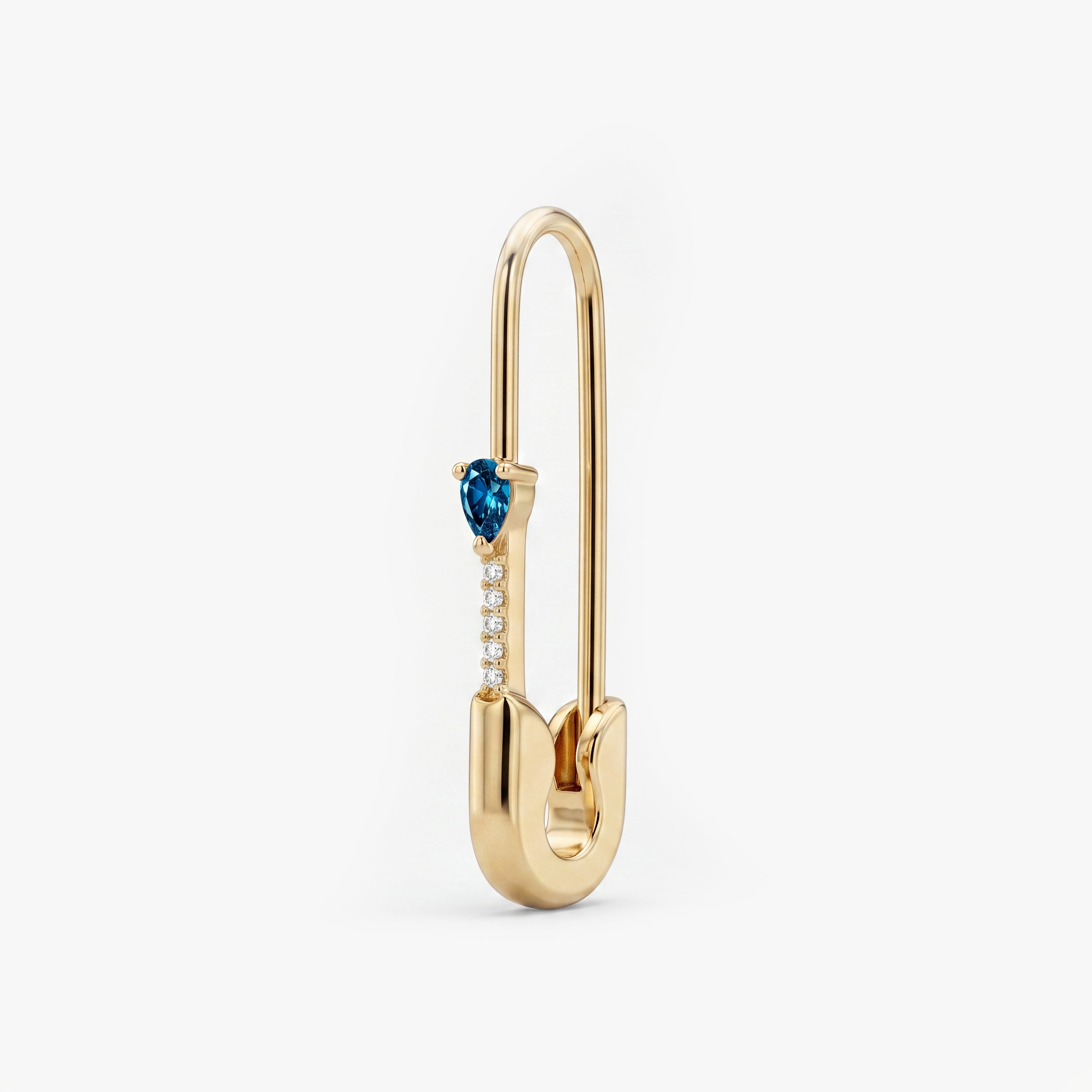 This is an image of a 14k yellow gold plated brass earring shaped like a safety pin with a blue pear cut CZ stone and 5 clear accent stones below the pear CZ. - Main view