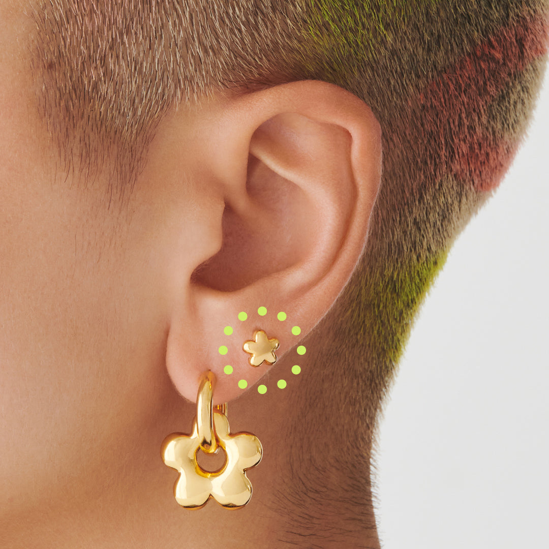 A gold puffy daisy-shaped stud on ear. [hover] color:null|gold