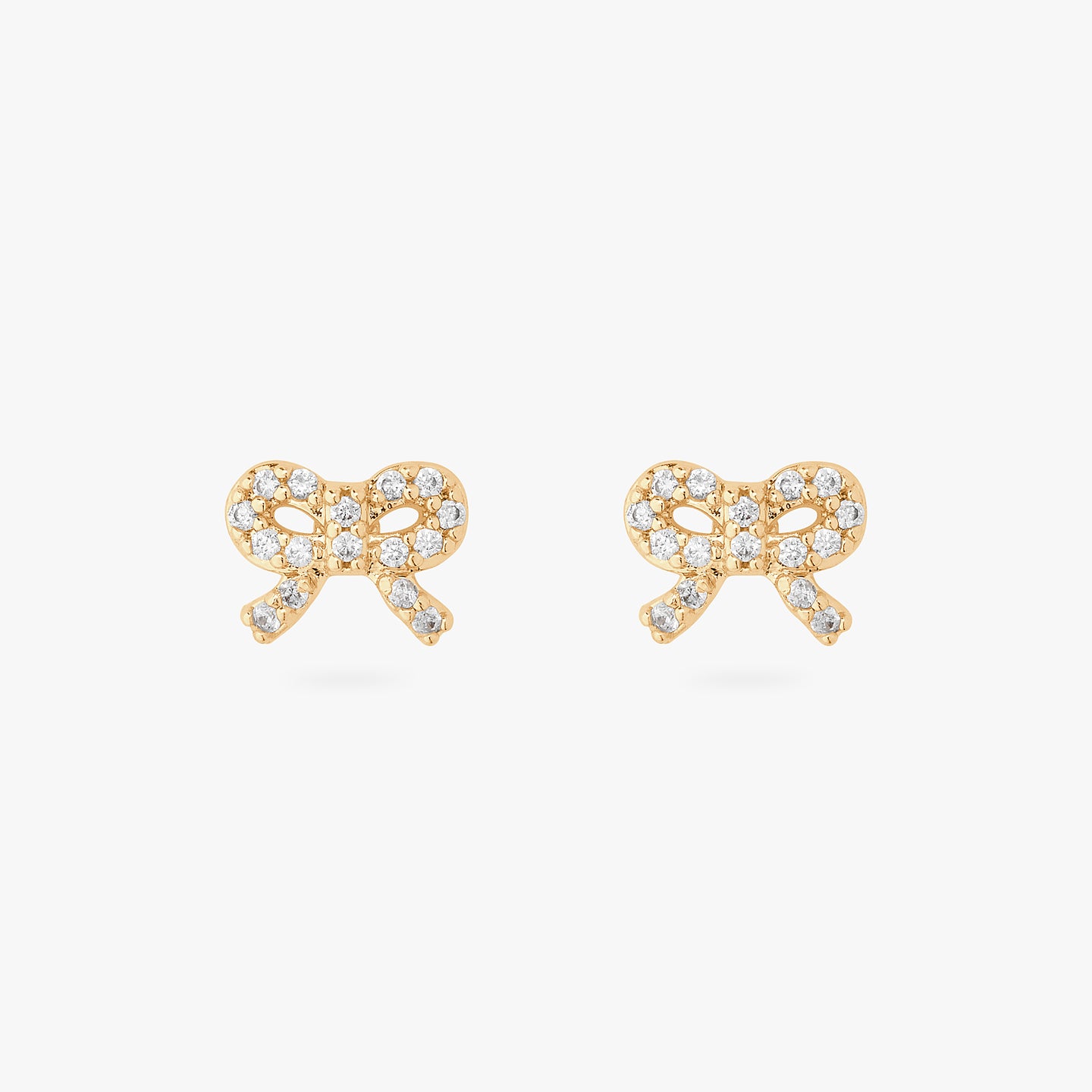 An image of a pair of gold/clear pave studs in the shape of a bow. [pair] color:null|gold/clear