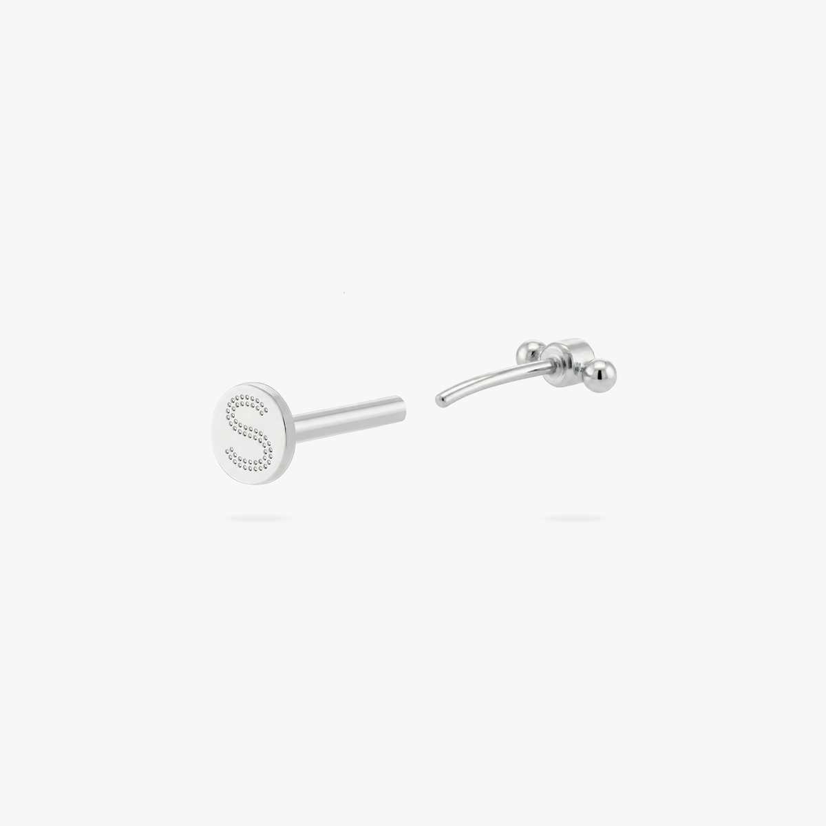 Open back angle of a flatback stud with an engraved 'S' logo on the post 