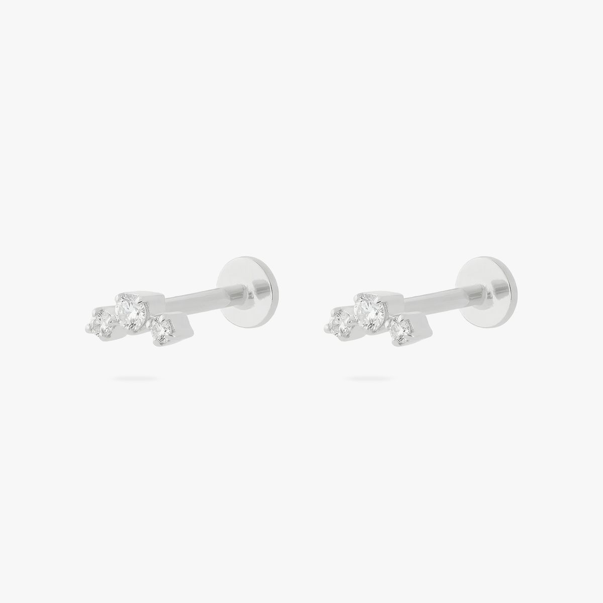 Pair of silver micro flatbacks on a white background