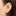 This is an image of a 14K gold flatback stud with a pointed star with a green cz stone in the center on ear. [hover] color:null|gold/green