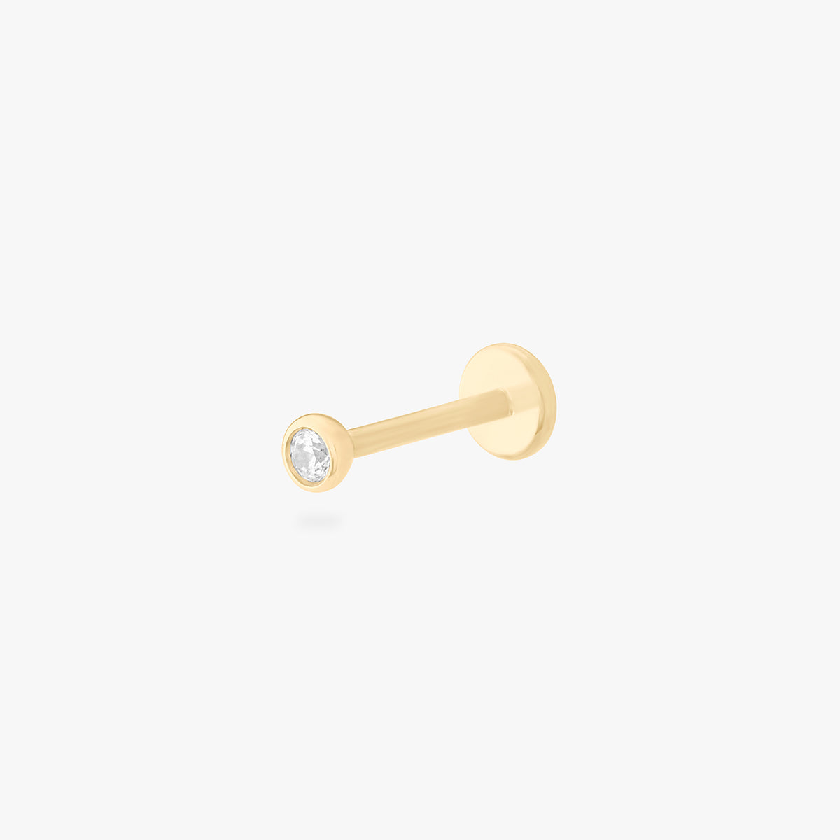 This is an image of a 14k gold flatback with a bezel setting and clear stone on ear. color:null|14k gold