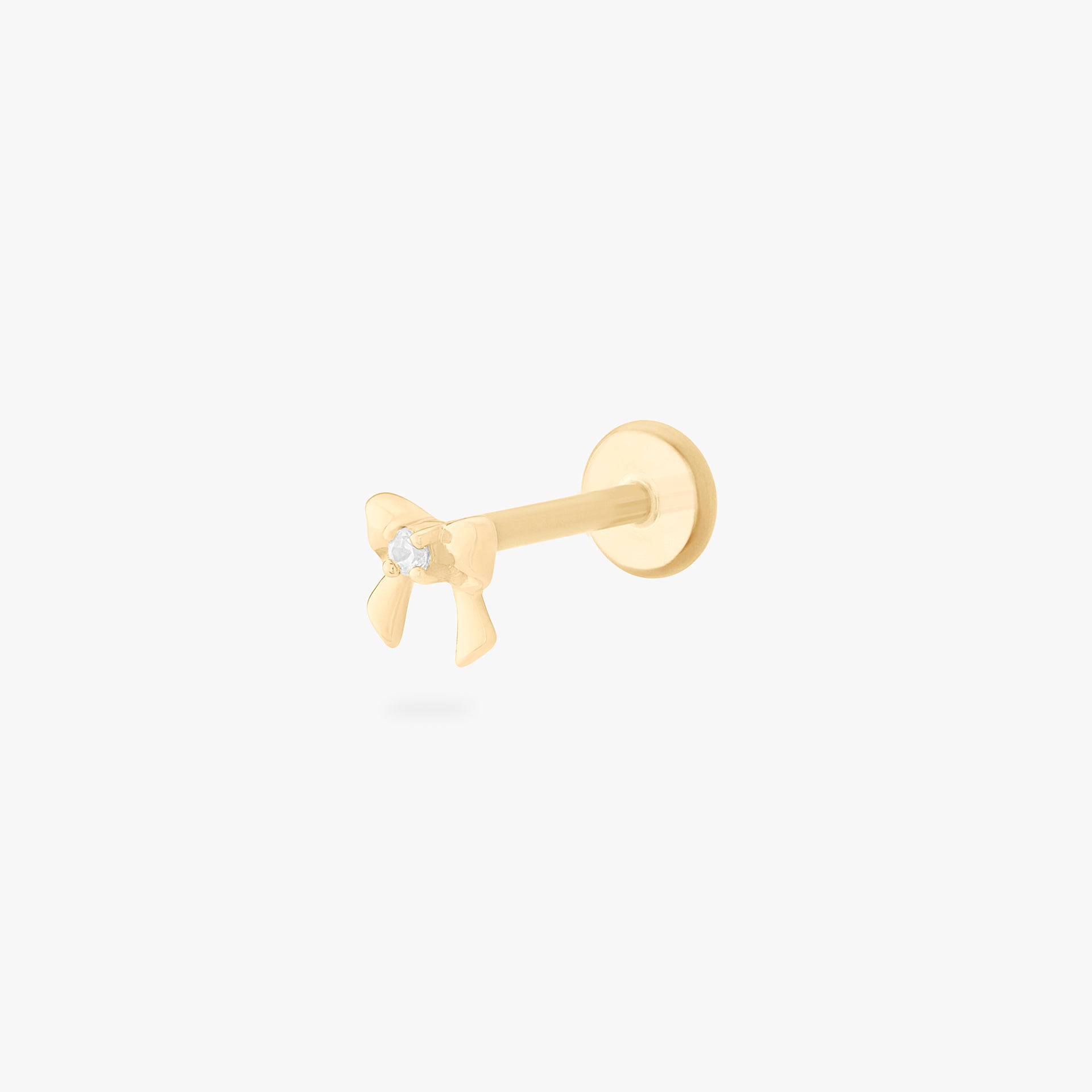 This is a 14k gold flatback stud that is bow shaped with a clear cz in the middle.