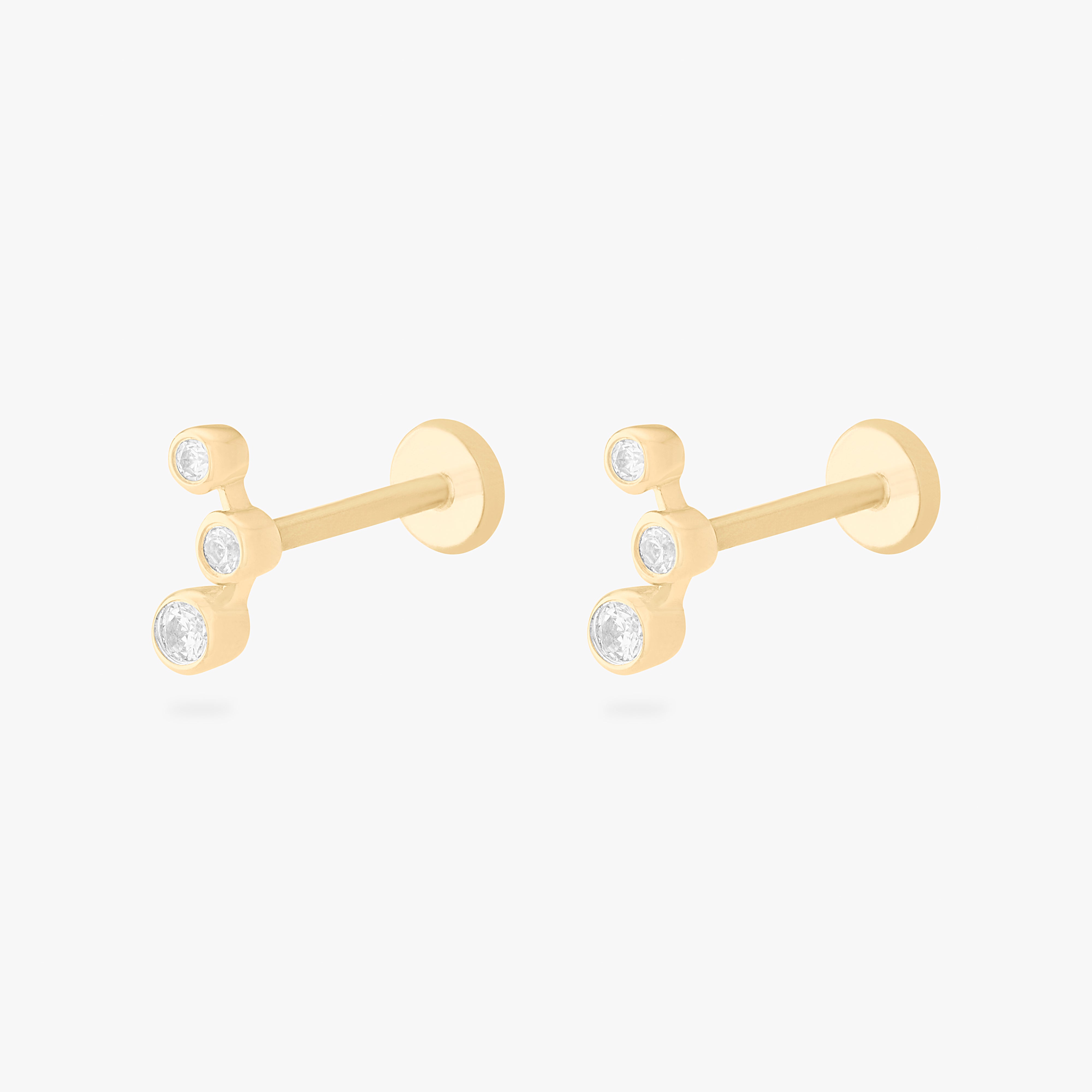 This is an image of a pair of 14k gold flatback studs with 3 clear cz bezels in a cluster shape. [pair] color:null|14k gold/clear