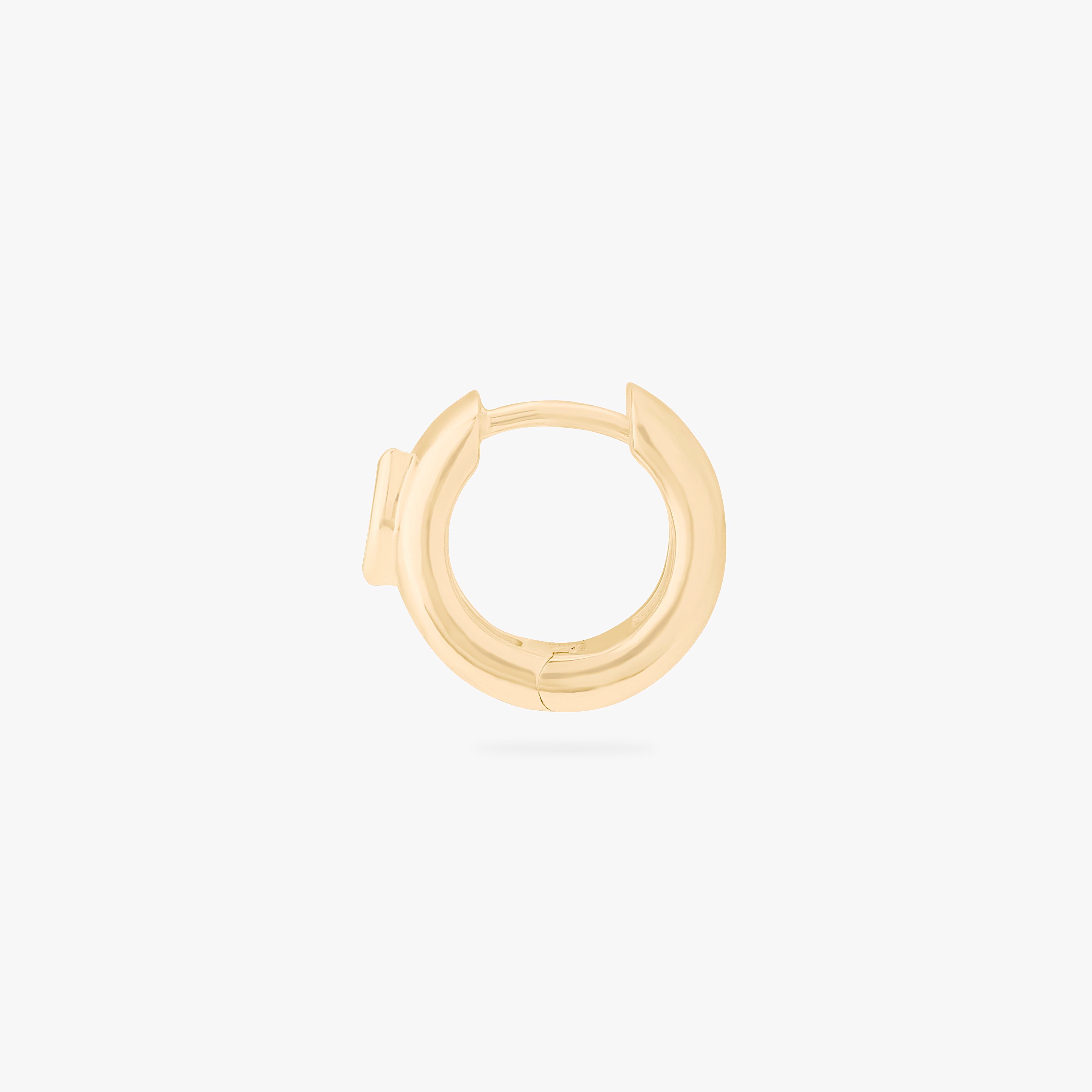 This is an image of a gold toned huggie that is chunky and has a marquise shaped cz in it. color:null|gold/clear