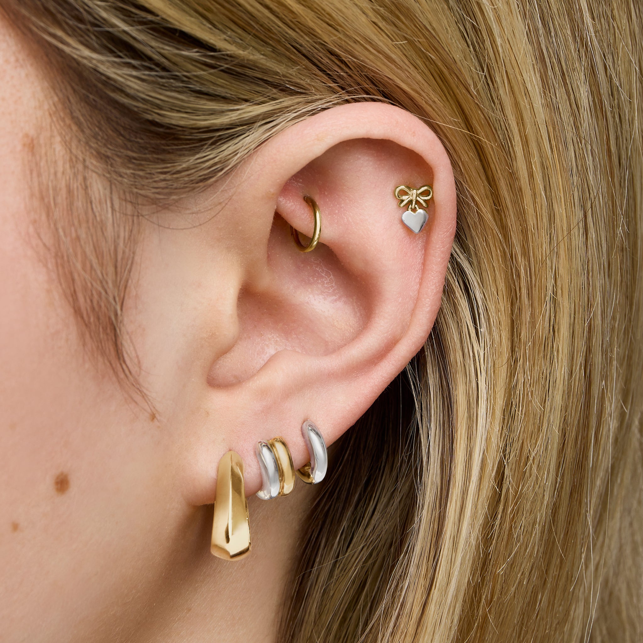 This is an image of a gold toned triangle-shaped hoop. [hover] color:null|gold