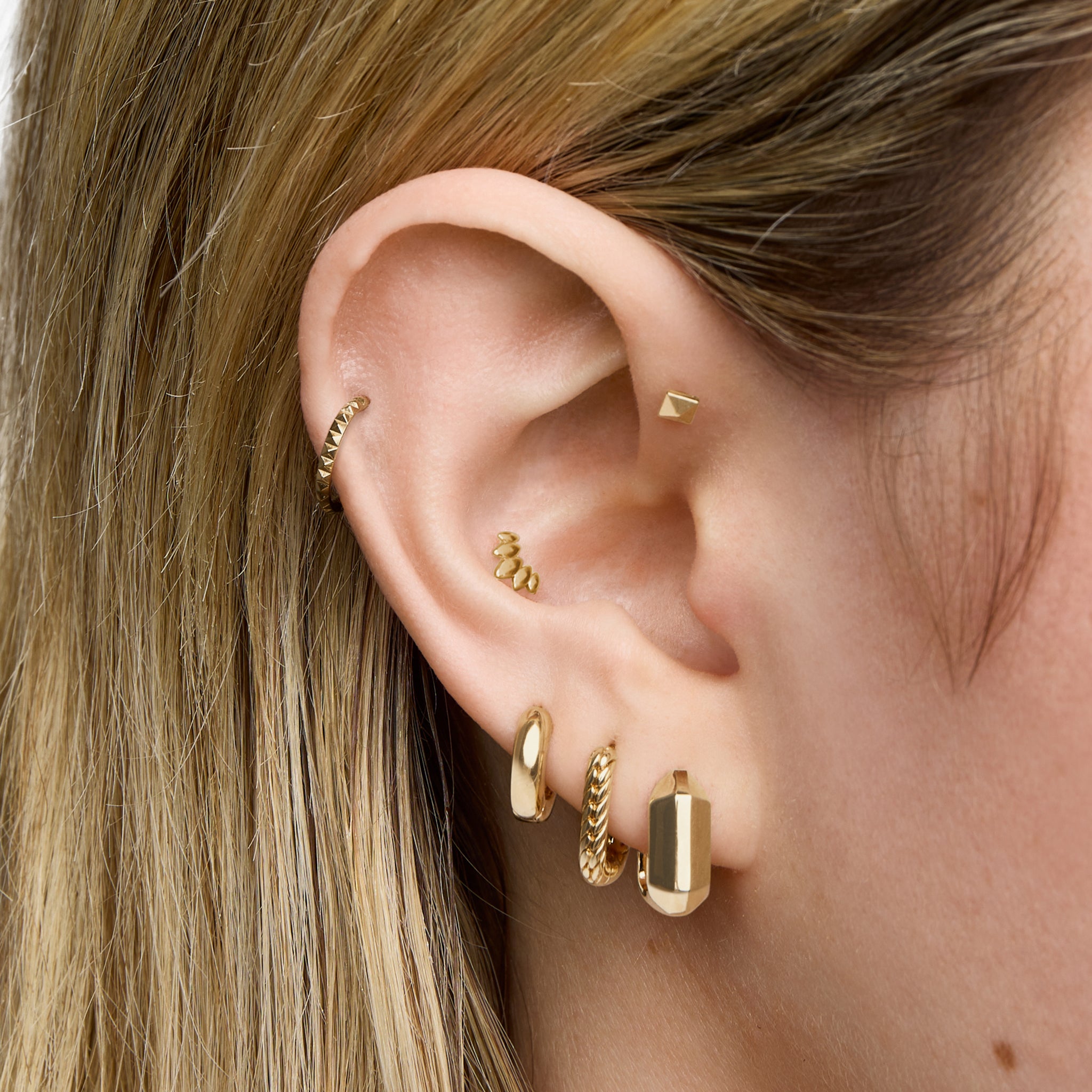 This is an image of a gold toned huggie that is square shaped. [hover] color:null|gold