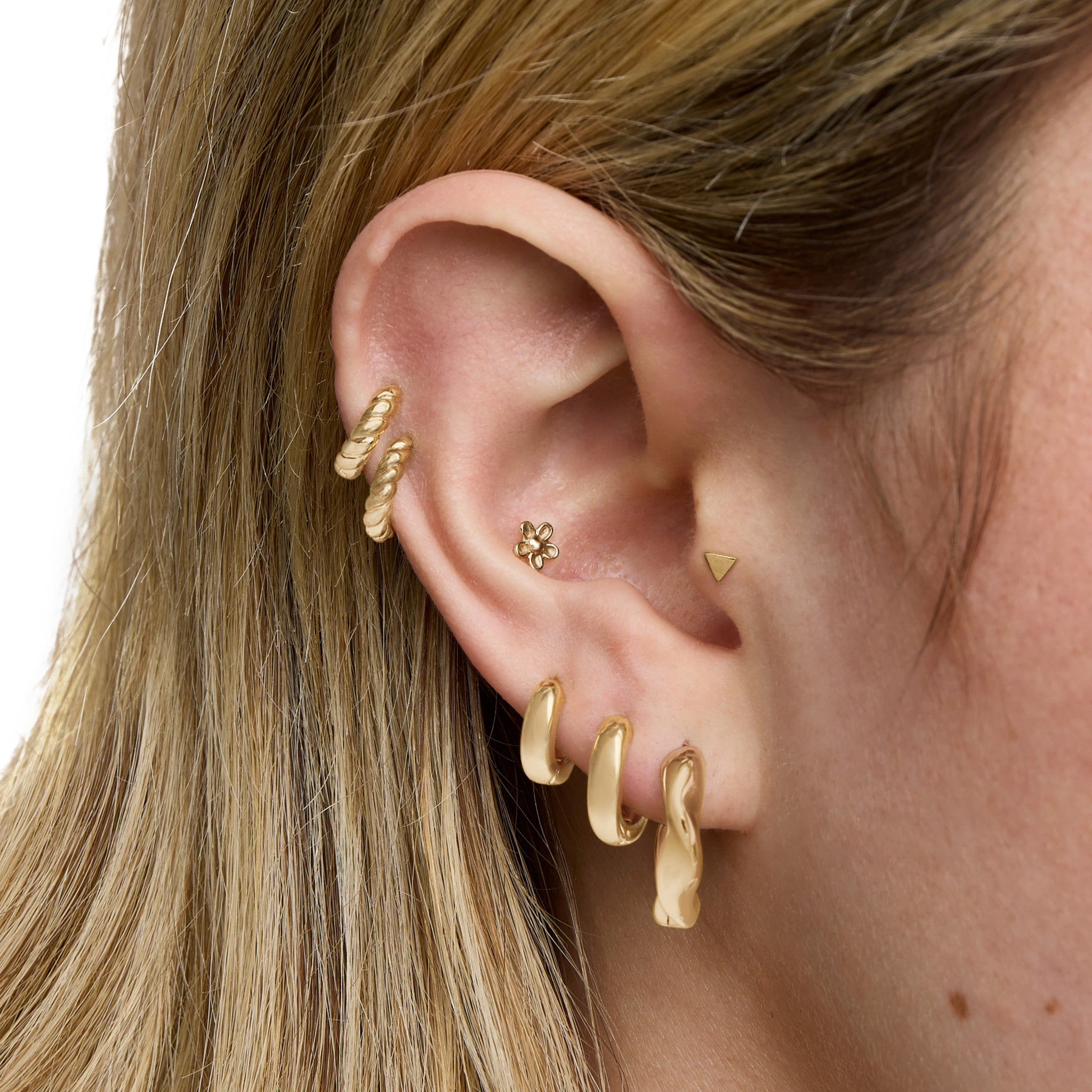 This is an image of a gold toned hoop earring that has a twist detail. [hover] color:null|gold
