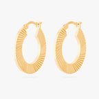 This is an image of a pair of 14K gold plated hoops that have a fluted, shell-like finish. 