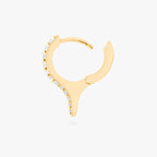 Gold huggie with a spike and small clear stones on a white background, side view with earring open
