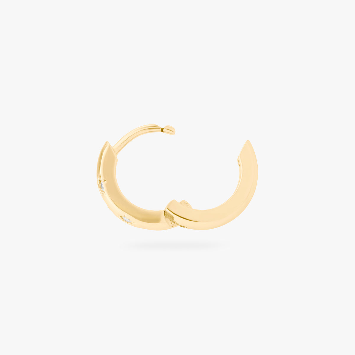 This image displays a 14K gold plated chunky huggie that features twinkle star shaped engravings with crystal CZ stones throughout the huggie against a white background. This image displays the huggie hinged open. 