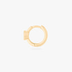 Gold huggie earring side view on a white background