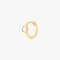 Gold huggie earring with a clear gemstone on a white background