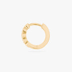 Gold hoop earring with embedded stones on a white background