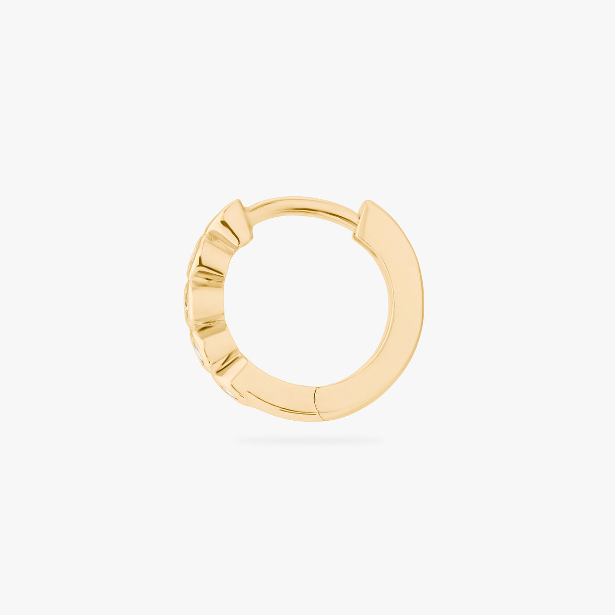 Gold hoop earring with embedded stones on a white background