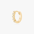 Gold hoop earring with embedded stones on a white background