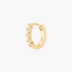 Gold hoop earring with embedded stones on a white background