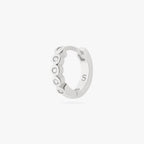 Silver hoop earring with embedded stones on a white background