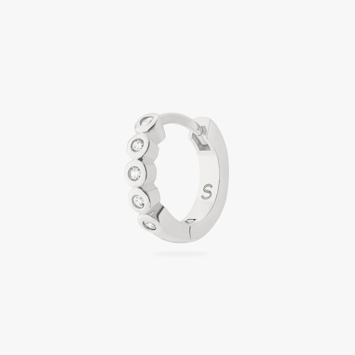 Silver hoop earring with embedded stones on a white background